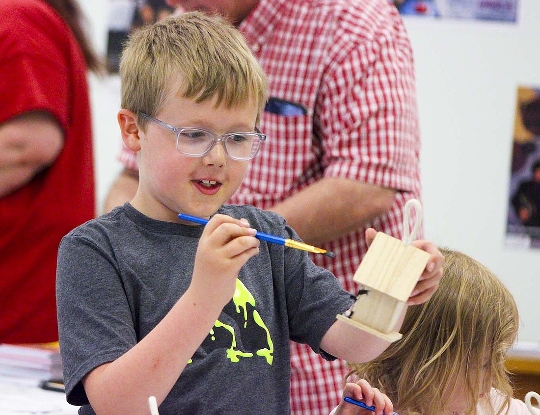 Carson Richards, 7, paints a bird house Saturday at Arts Place during the Arch Bridge Festival on Main Street in Portland. Arch Bridge Kroozers set up their annual car show Saturday along the street and around Jay County Courthouse, and vendors set up stations on the street just east of Meridian Street (U.S. 27). (The Commercial Review/Bailey Cline)
