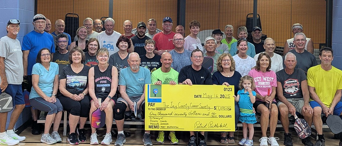 Patriot Pickleball players and friends played pickleball and table tennis May 16 for a free will donation event benefiting Jay County Cancer Society.  This annual event is held in memory of Daniel Johnson, Mary Brotherton and Roger Prescott. The players raised $1,070. Pictured above are pickleball and table tennis players, with (from left holding sign) Eric Butcher, Darwin Johnson and Carla Johnson. (Photo provided)