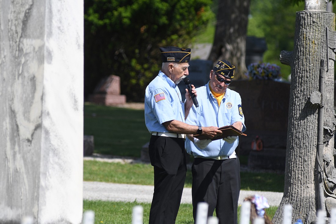 Portland American Legion Post 211 commander Butch Micheau holds a speech in place for pastor Darrell Borders during Monday’s breezy Memorial Day Service at Green Park Cemetery in Portland. Borders gave an address during the ceremony that also included patriotic songs, a 21-gun salute by the legion honor guard and the playing of “Taps.” (The Commercial Review/Ray Cooney)