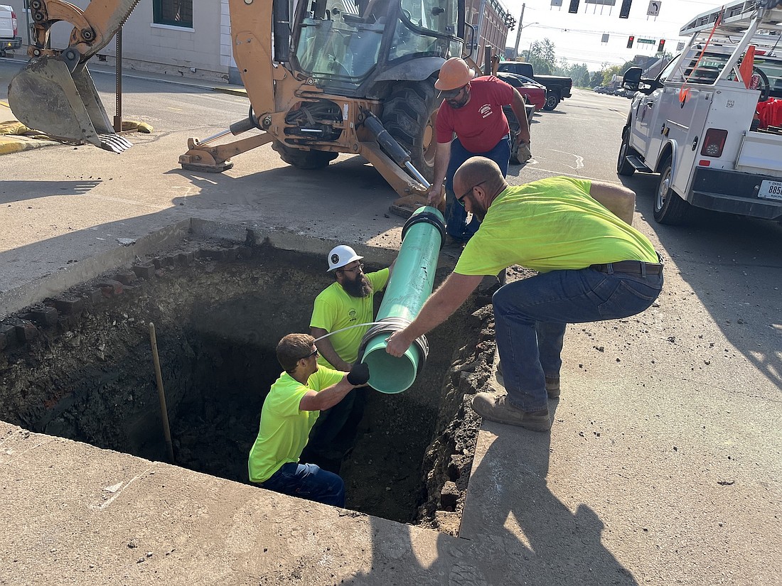 Ryan Sheffer, Dustin Somers, Brandon Davis and Mike Cline move a new section of sewer tile while working Thursday morning on Main Street just west of Meridian Street in Portland. The crew was working on replacing a damaged section of the sewer line. (The Commercial Review/Ray Cooney)