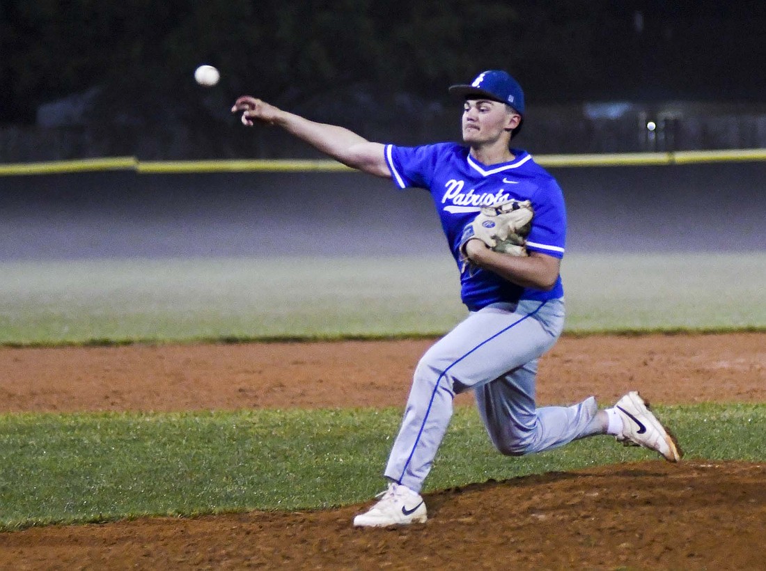 Jay County High School junior Aiden Phillips slings a pitch during the bottom of the 12th inning during the Patriots’ 10-2 win over New Castle in the IHSAA Class 3A Sectional 24 opener at Yorktown on Wednesday. Phillips shut down the Trojan’s lineup over the final 5 ⅔ innings, only allowing two hits and two walks without giving up a single run. (The Commercial Review/Andrew Balko)