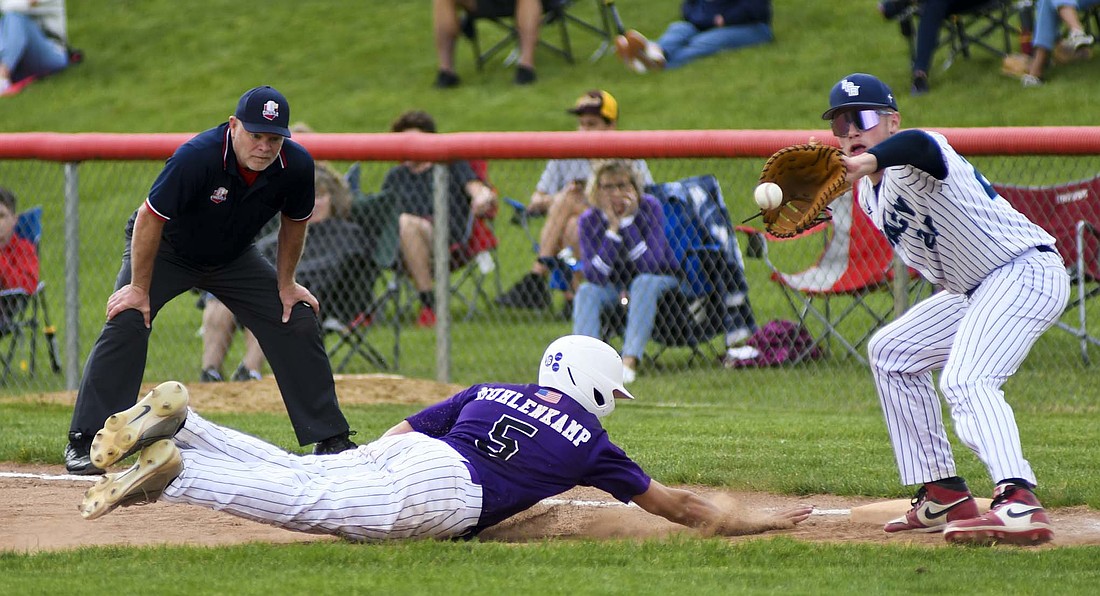 Fort Recovery High School’s Keegan Muhlenkamp dives back to first base while Legacy Christian’s Nathan Whitt receives a pickoff attempt at Houston High School on Friday. The Indians beat the Knights 2-1 in nine innings on a walk-off double smashed by Colson Post. (The Commercial Review/Andrew Balko)