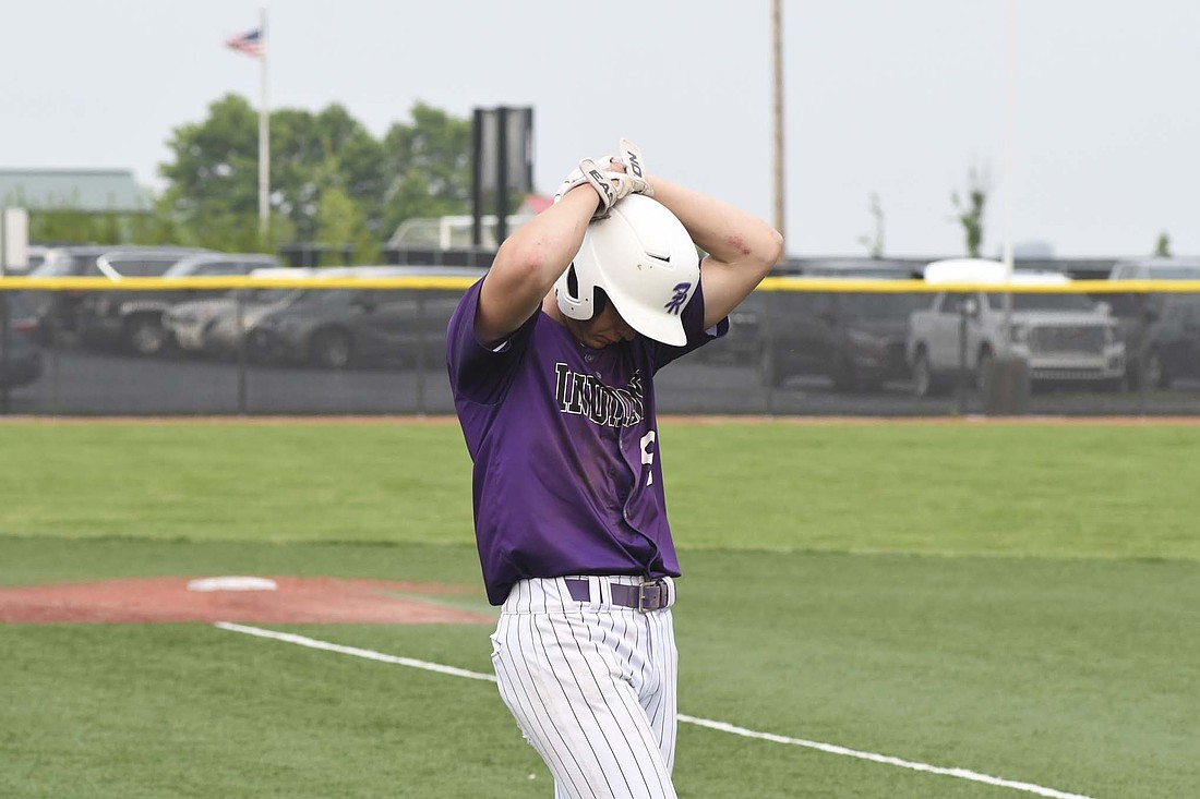 Fort Recovery High School’s Gavin Evers clasps his hands over his helmet after hitting a flyout to end the OHSAA Division VI Region 24 championship game against Fairview at Newton on Wednesday. The Indians fell one game short of their second straight state appearance after giving up four unearned runs in a 7-1 loss to the Apaches. (The Commercial Review/Andrew Balko)