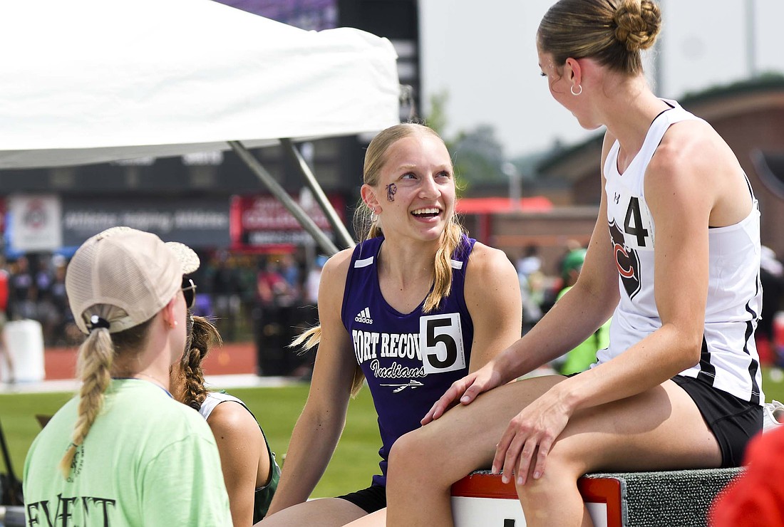 Fort Recovery High School senior Anna Roessner grins Saturday while chatting with rival Izzy Zahn of Coldwater while awaiting the medal ceremony for the 200-meter dash during the OHSAA Division III Track and Field State Finals at Jesse Owens Memorial Stadium on the campus of Ohio State University in Columbus. Roessner finished second to Zahn in the 200 dash after winning the 100 dash earlier in the day to become the first FRHS girls track state champion. Roessner set a new state meet record in the 100 dash and tied the all-time Division III record, while Zahn set state meet and Division III records in the 200 dash and 400 dash. (The Commercial Review/Ray Cooney)
