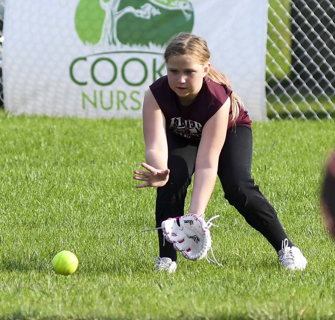 Left-center fielder Mylee Noggler prepares to trap a ground ball that made its way to the outfield during a Monday matchup between Fisher Meats and Crossroads FCU in Portland Junior League Minor softball play. (The Commercial Review/Andrew Balko)