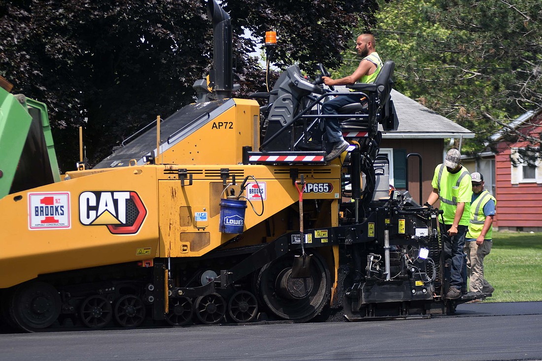 A crew from Brooks Construction of Fort Wayne works on paving Charles Street near its intersection with Arch Street on Thursday morning. The street is being paved between Votaw and Water streets. (The Commercial Review/Ray Cooney)