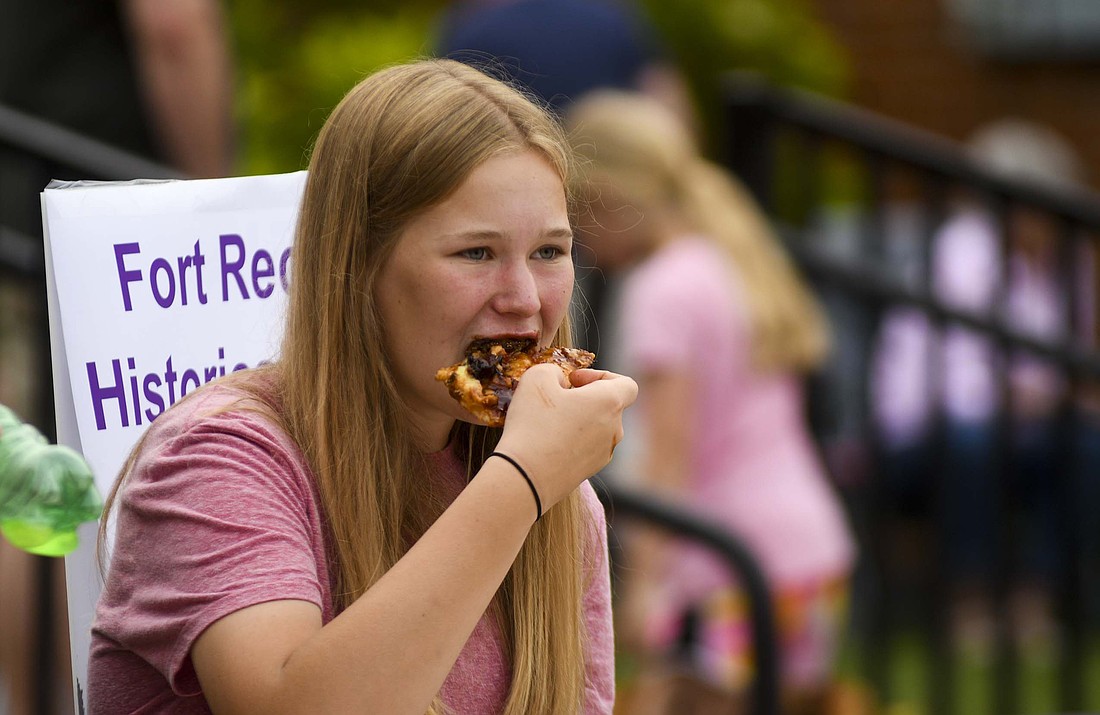Fort Recovery Harvest Jubilee activities got underway Thursday with the Taste of Fort Recovery on the brick portion of Wayne Street. Pictured above, 13-year-old Makayla Wehrkamp enjoys a bite of pizza, one of the many food offerings available during the event. (The Commercial Review/Ray Cooney)