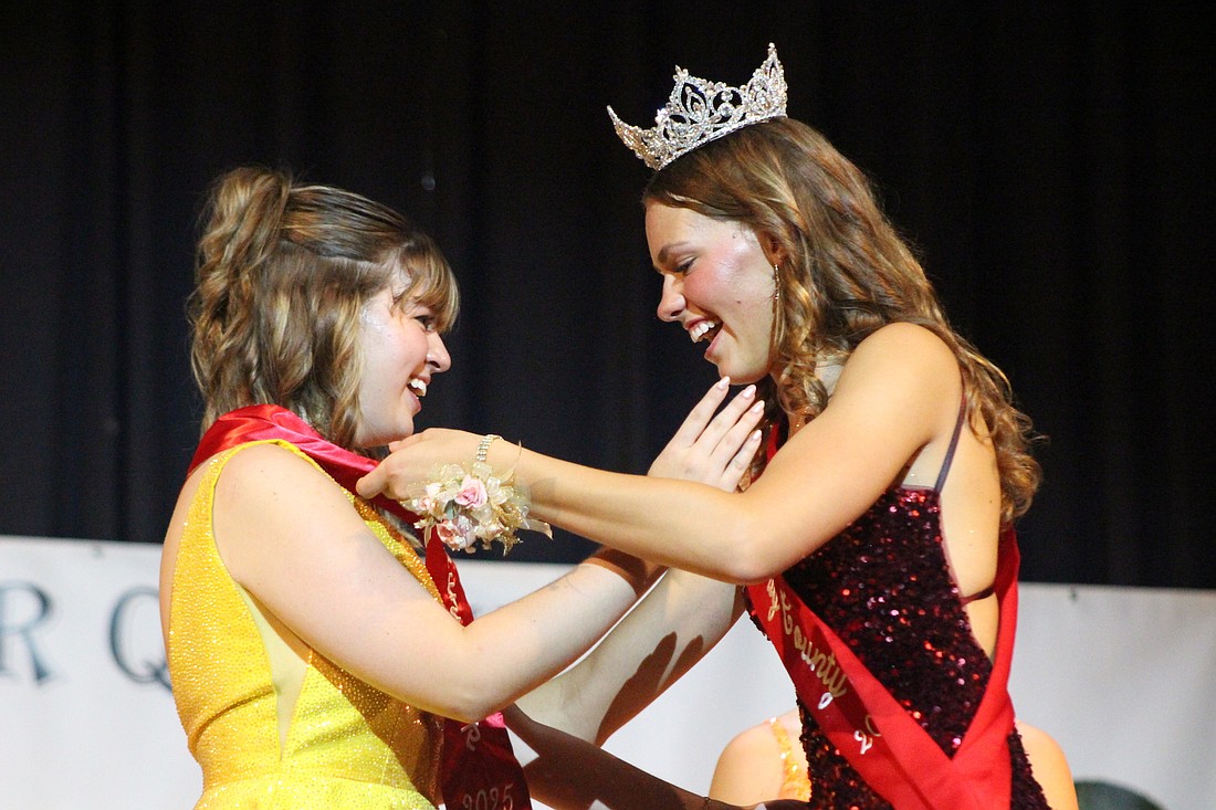 Jasmine Esparza accepts her second runner-up sash Sunday from 2024 Miss Jay County Molly Muhlenkamp at the end of the fair queen pageant at Jay County Junior-Senior High School. (The Commercial Review/Bailey Cline)