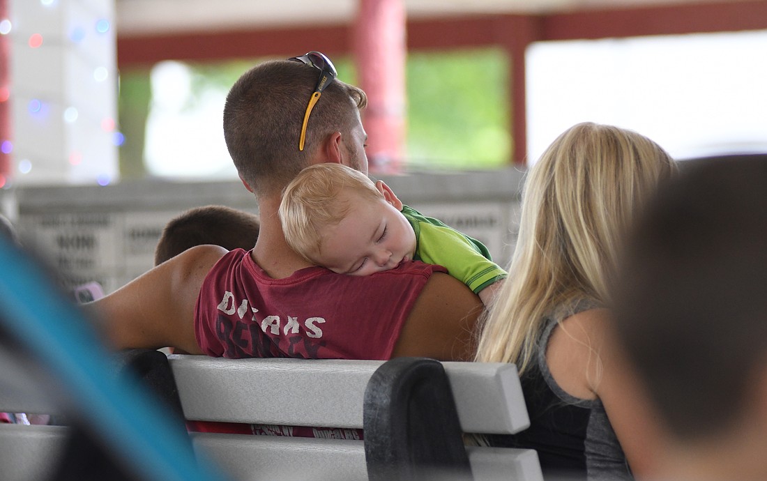 The Jay County Fair continued over the weekend and Monday with a variety of 4-H shows, grandstand entertainment and Farmer’s Building events. Pictured above, Brayden Alig, 7 months, takes a nap on father Nick’s shoulder in the Farmer’s Building during the Little Miss & Mr. Jay County Fair Contest on Saturday. (The Commercial Review/Andrew Balko)