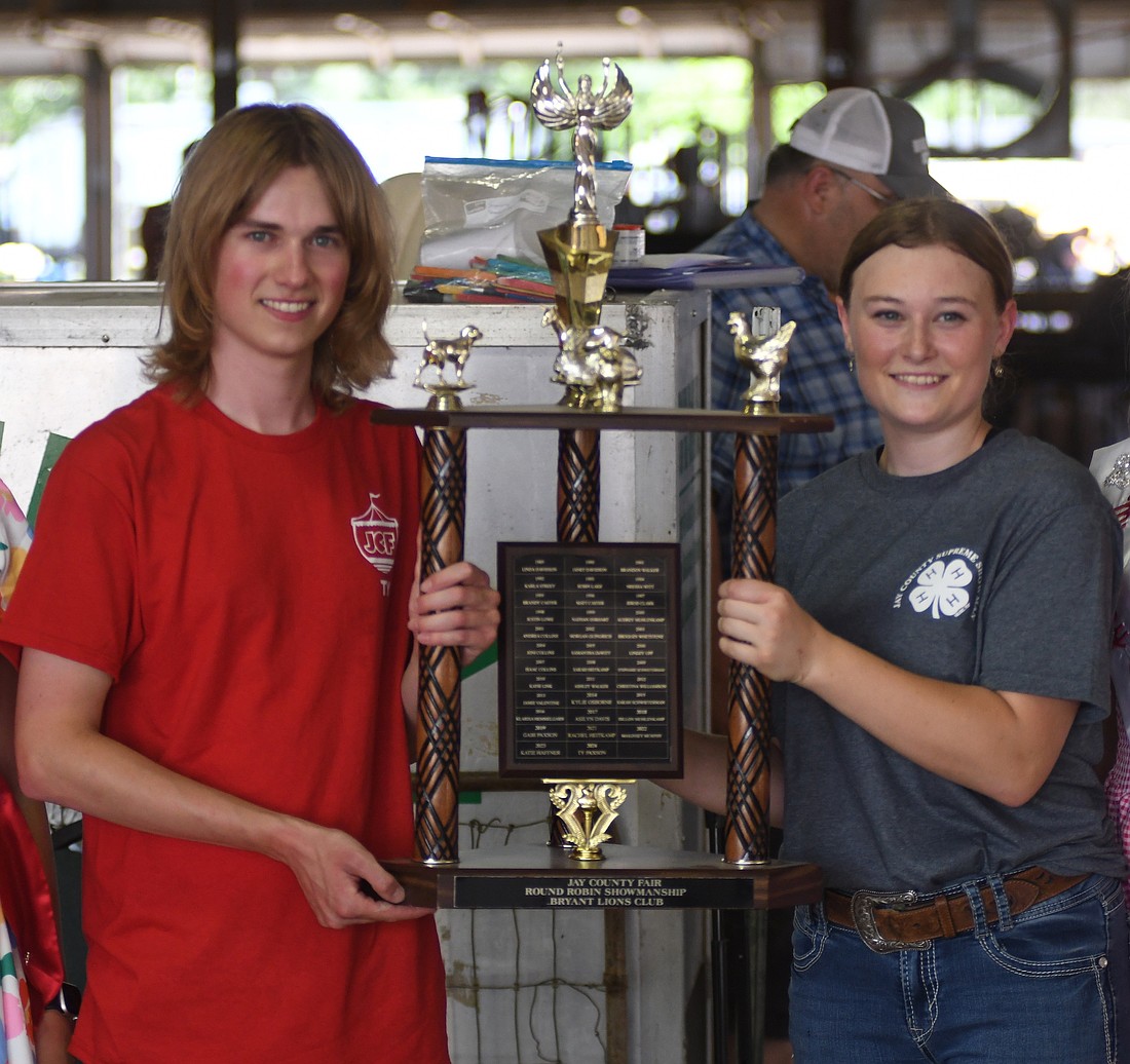 Aubree McClure (right) poses for a picture after winning the Jay County 4-H small animal supreme showmanship competition on Tuesday afternoon. Ty Paxson (left), the 2024 champion, presented her with the trophy. McClure topped an experienced field as all five competitors have been in the small animal competition at least once before. (The Commercial Review/Ray Cooney)