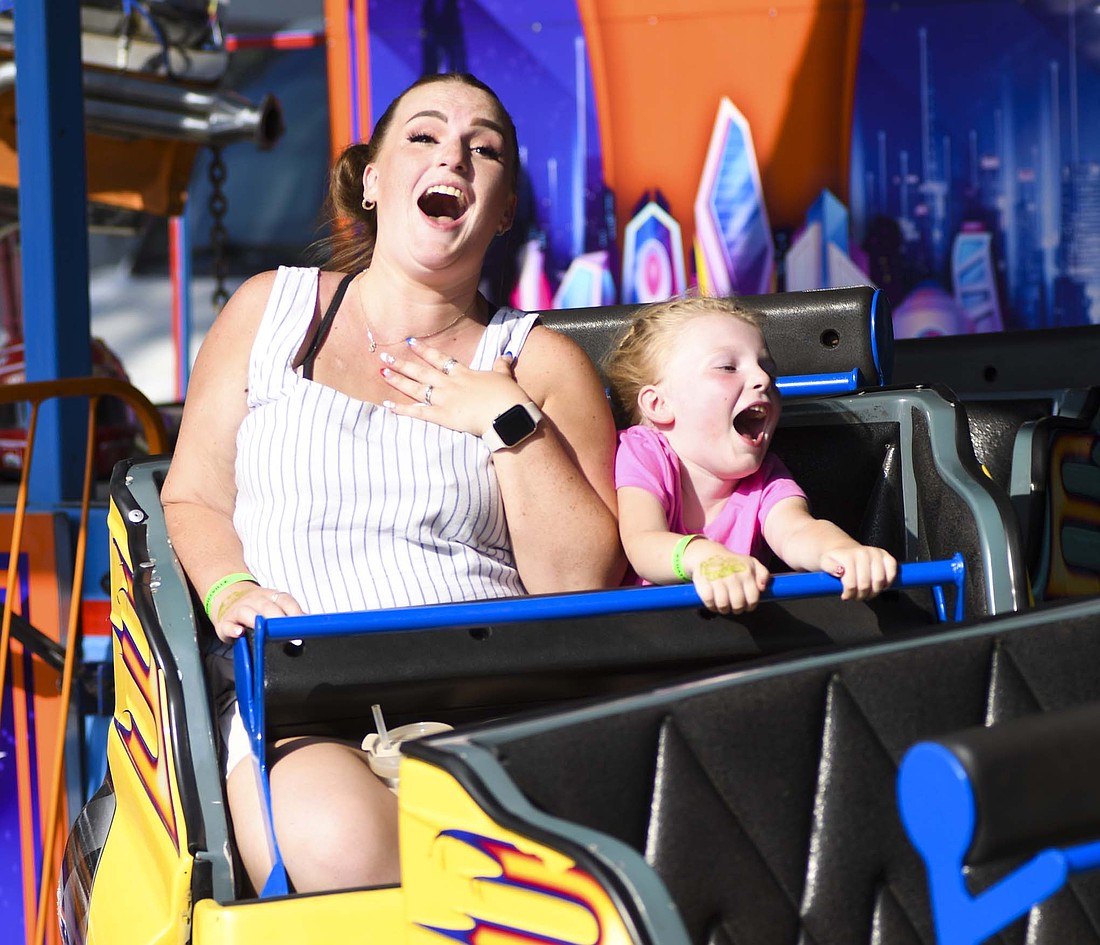 Jenna Pitman and Kathleen Pitman, 6, laugh while going around the Hot Rods ride on the midway. (The Commercial Review/Andrew Balko)