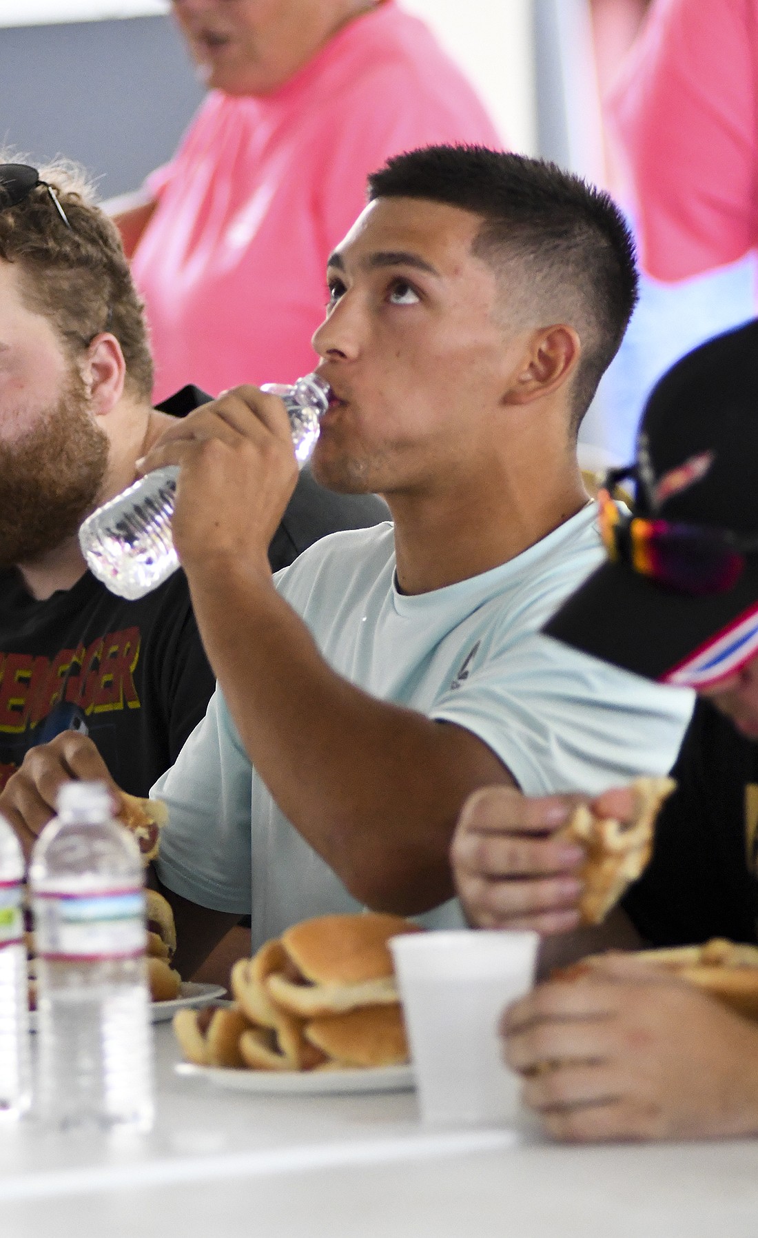 Tony Wood takes a sip of water while trying to keep his food down during the inaugural hot dog eating contest in the Farmer’s Building on Saturday. The winner of the contest, Sheldon Upp, got down eight hot dogs in under 10 minutes. (The Commercial Review/Andrew Balko)