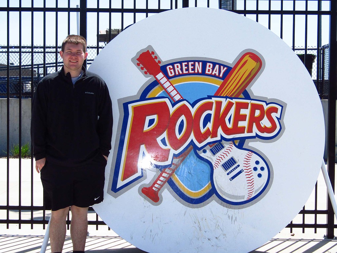 Ryne Goldsworthy stands next to the Green Bay Rockers sign outside of Capital Credit Union Park in Ashwaubenon, Wisconsin. Goldsworthy landed a stadium operations internship with the Rockers for the summer, getting him some early sports administration experience. (Photo provided)