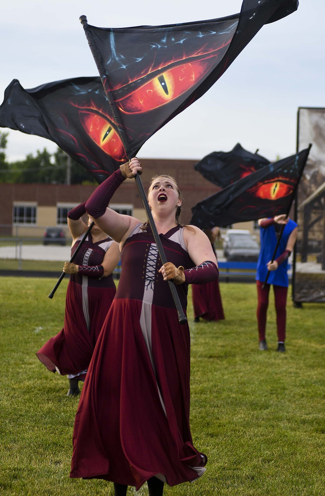Audrey Evans spins her flag displaying a dragon’s eye during the Jay County High School Marching Patriots’ performance Saturday during the Centerville Archway Classic. The band is using alternate uniforms this year to create a medieval look to help tell the story of a village attacked by a dragon and the rise of a hero. The band will take the track again Friday night in the Jay County Lions Band Contest at Jay County Fairgrounds. (The Commercial Review/Ray Cooney)