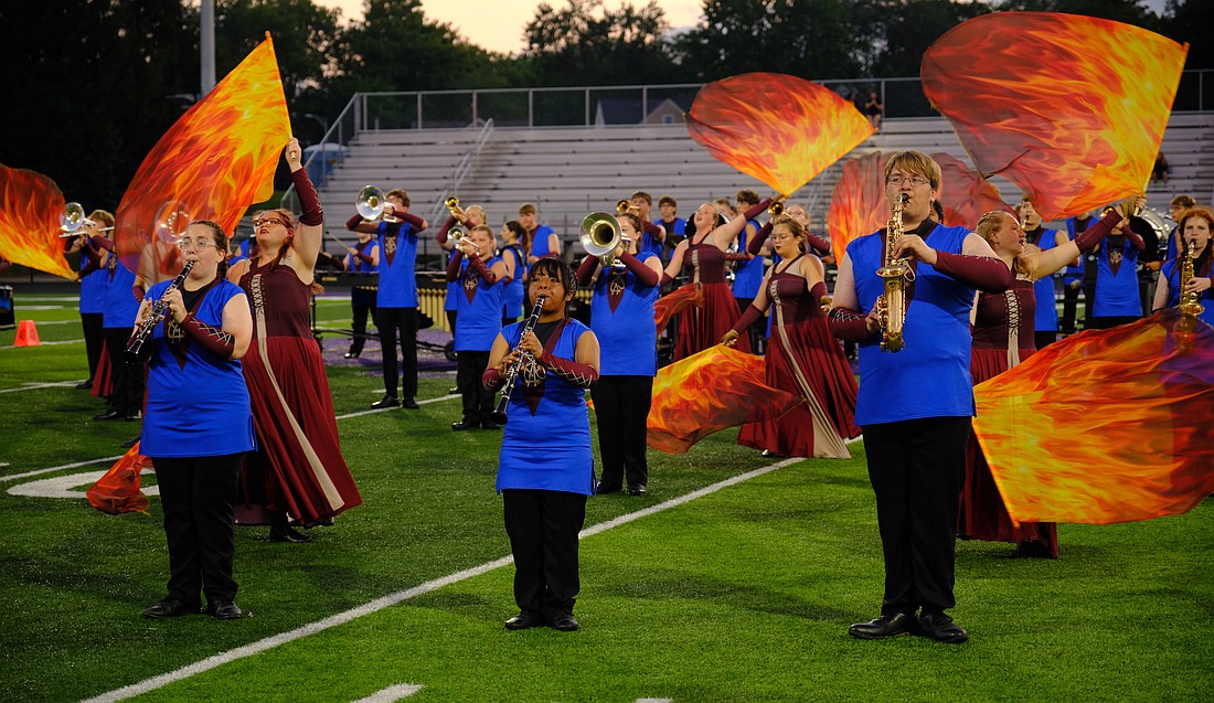 The Jay County High School Marching Patriots scored 69.875 points to finish fifth Saturday in the Spirit of Sound band contest at Muncie Central. JCHS trailed defending Indiana State Fair champion Muncie Central (77.888), Kokomo (75.3), Anderson (75.275) and Richmond (72) while finishing just over a point ahead of Winchester (68.688) in the field of 23 bands. Pictured above in front, from left, are clarinet players Ava Franks and Julianna Hernandez, and saxophone player Troy Lee. The Marching Patriots are at band camp this week. Below, the Jay County High School Marching Patriots await their turn to take the field in front of a packed Muncie Central football stadium during the Spirit of Sound contest on Saturday night. JCHS will be back in competition on Saturday in the Drums at Winchester. (Special to The Commercial Review/Evelyn Garringer)