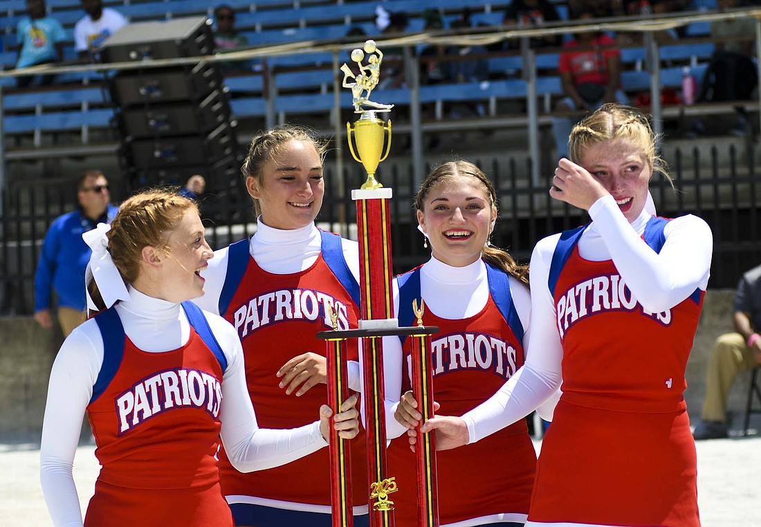 There were smiles and tears from the Jay County High School cheerleaders Saturday afternoon as they claimed the first place trophy in the large varsity no music division at the Indiana State Fair, Pictured, from left, Emma Hatzell, Paisley Fugiett, Kayla Jetmore and Faith Faulkner react as they carry the trophy back to their teammates. The victory was the first for the Patriots since 2012 and a redemption of sorts after coming up 0.1 points short last summer. (The Commercial Review/Ray Cooney)