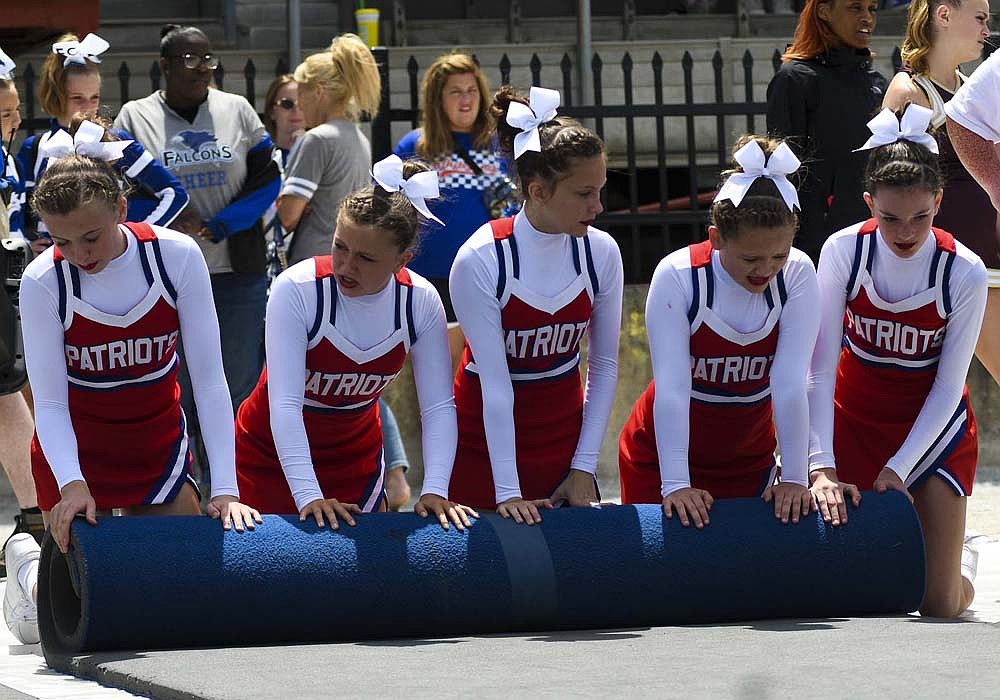 Jay County Junior-Senior High School’s cheerleaders jumped in to help roll up and haul the mats following Saturday’s competition at the Indiana State Fair. Pictured, from left, Leah Steed, Journey Reynolds, Aubree Hunley, Lilly Stephen and Bailey Muhlenkamp of the junior high squad work together to start rolling up a mat. (The Commercial Review/Ray Cooney)