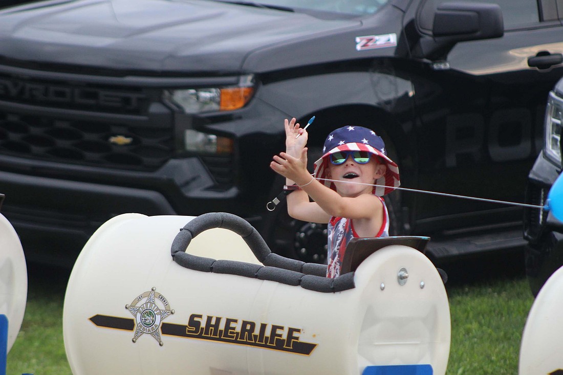 Portland Police Department hosted its National Night Out event Tuesday at Hudson Family Park. Pictured, a boy waves while in the Jay County Sheriff’s Office bucket rides. (The Commercial Review/Bailey Cline)