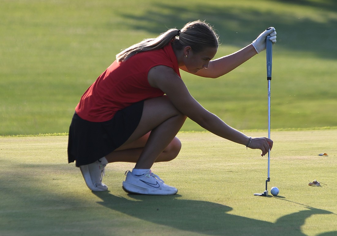Elizabeth Brunswick of the Jay County High School girls golf team lines up a putt during Monday's 235-241 loss to Heritage at Portland Golf Club. Brunswick shot a 56 to share match medalist honors. (The Commercial Review/Ethan Oskroba)