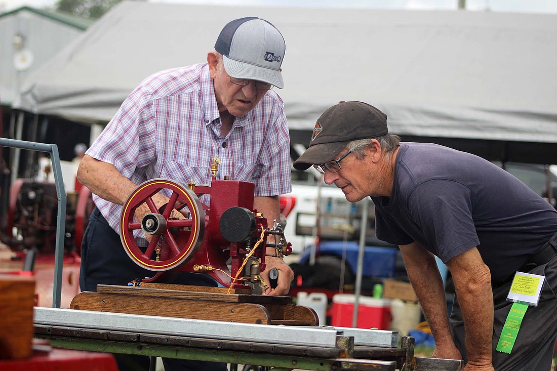 Gary Arnold of Marietta, Ohio, examines his Domestic farm engine model with Jim Rush of Union City on Thursday at Jay County Fairgrounds. Arnold — he’s been a regular attendee at the Tri-State Antique Engine and Tractor Show for about 55 years — builds scale models of different engines. Some of his creations on display at the fairgrounds through Saturday include replicas of E.H. Myers & Bro., International and Fairbanks Morse engines. Arnold and Rush met at the show years ago and forged a lifelong friendship. (The Commercial Review/Bailey Cline)