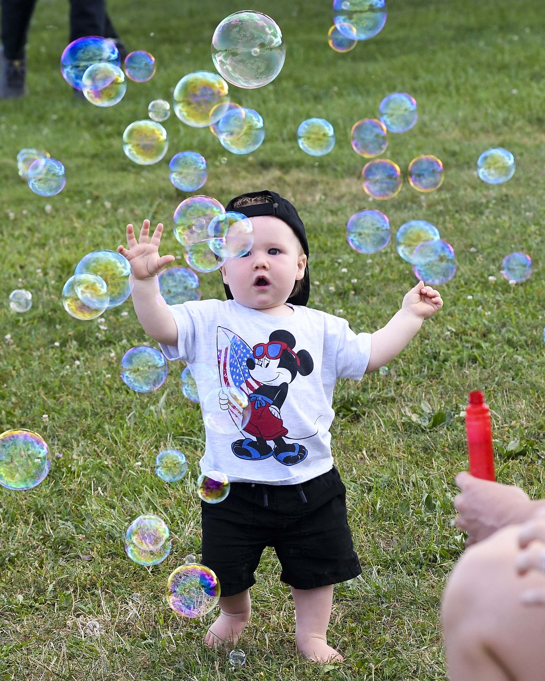 Jay County High School football fans had some fun Friday night with a pre-game tailgate party that included music from John Beatrice Band, food, games and other activities. Pictured, 1-year-old Frank Hess plays in the midst of a bunch of bubbles blown by his aunt Gabby Williams. The Patriots gave the fans plenty to be bubbly about as they scored the game’s first 23 points on the way to a 56-6 win over the visiting Blackford Bruins. (The Commercial Review/Andrew Balko)
