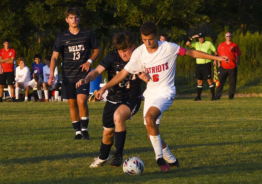 Jay County High School’s Jaxson DeHoff tries to use his body to shield off Delta’s Drayton Swanson during Thursday’s 3-1 loss. Emmitt Reynolds scored the sole goal for the Patriots as they fell to 2-1-1 on the season. (The Commercial Review/Ethan Oskroba)