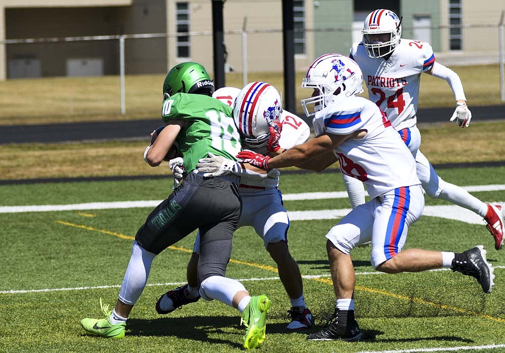 Brayden Fox and Bo Brunswick of Jay County High School try to keep New Castle quarterback Carson Bell from reaching the end zone on a first-quarter run Saturday afternoon. The host Trojans built a four-touchdown lead in the first half and handed the Patriots a 35-0 defeat. (The Commercial Review/Ray Cooney)