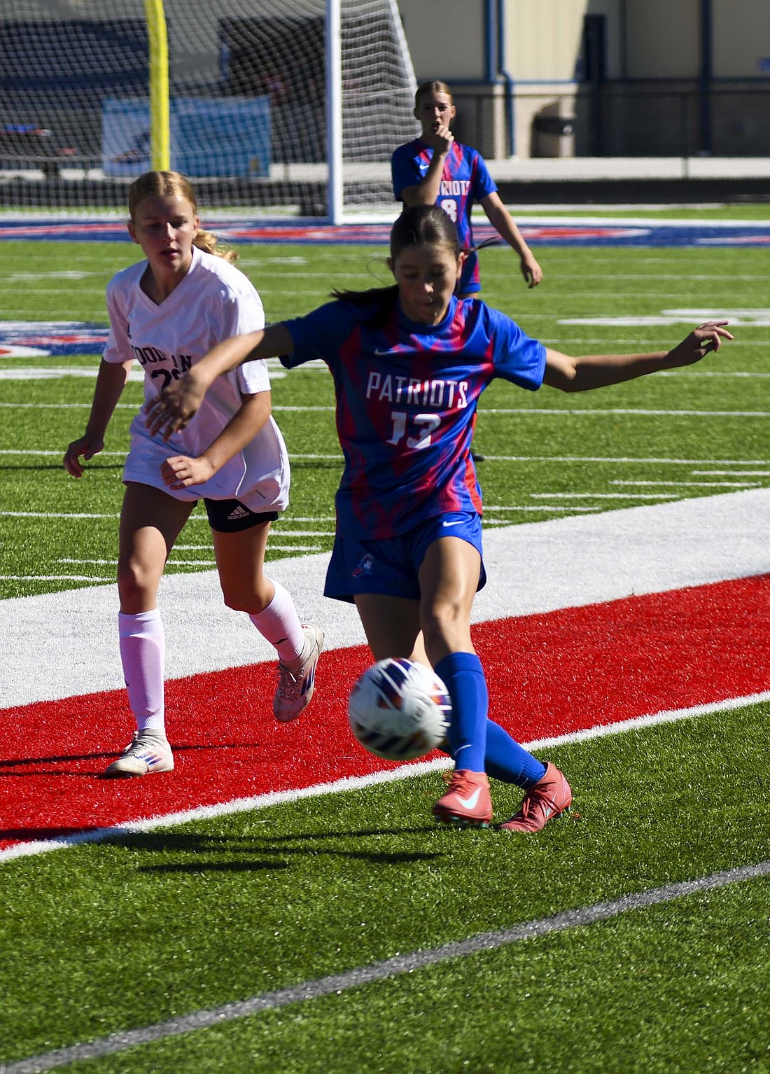 Freshman midfielder Maria Laux plays a ball down the sideline in Jay County’s home match against Woodlan on Saturday. Three different Patriots found the back of the net in a balanced effort that led to a 3-1 win. (The Commercial Review/Ethan Oskroba)