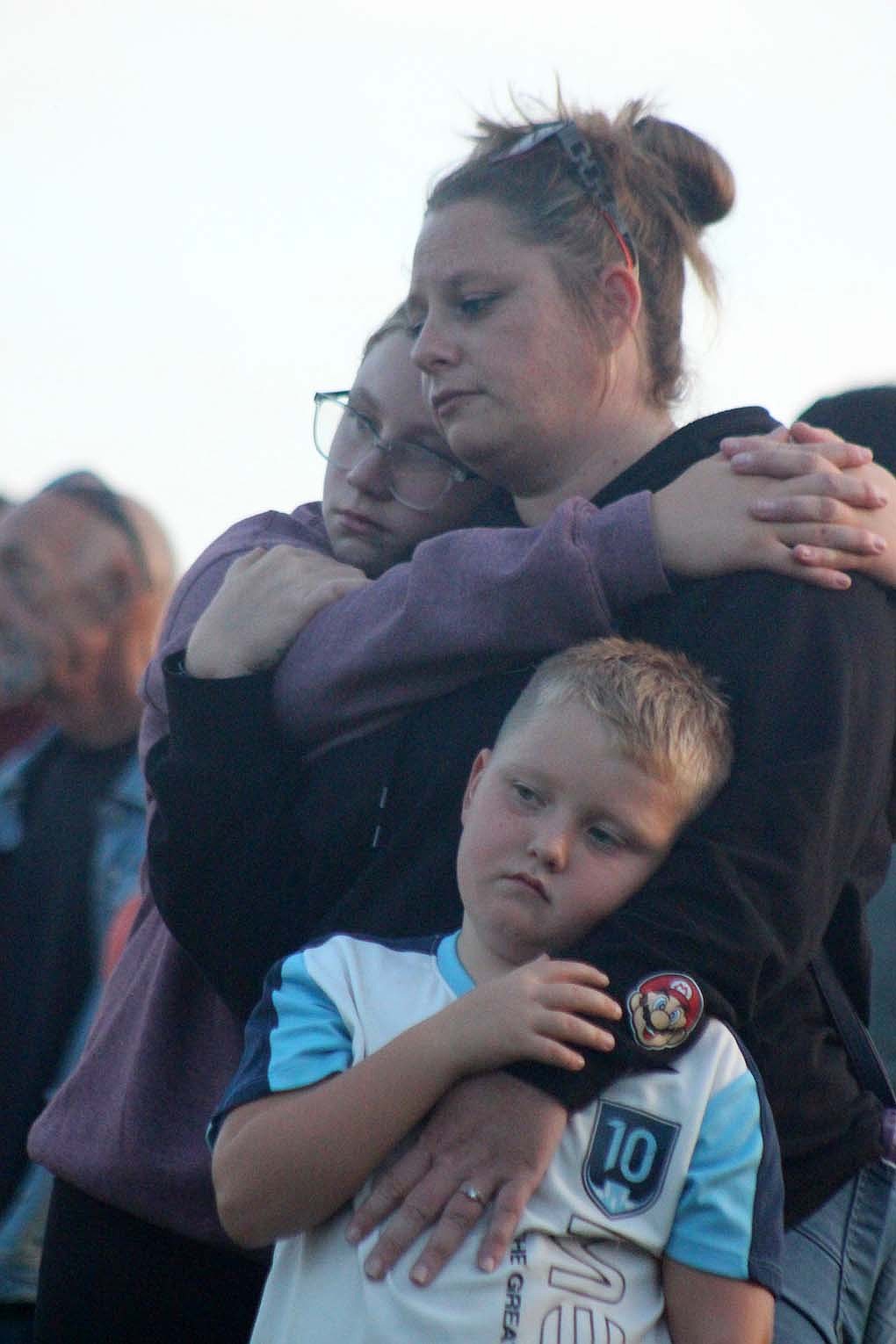 Ashley Rockwood of Portland hugs her niece and 8-year-old son, Connor Oliver, during a moment of silence Friday at Hudson Family Park. Jay County Drug Prevention Coalition hosted an overdose awareness memorial, lighting lanterns and sending them out across the pond in memory of those who have died from overdose. (The Commercial Review/Bailey Cline)