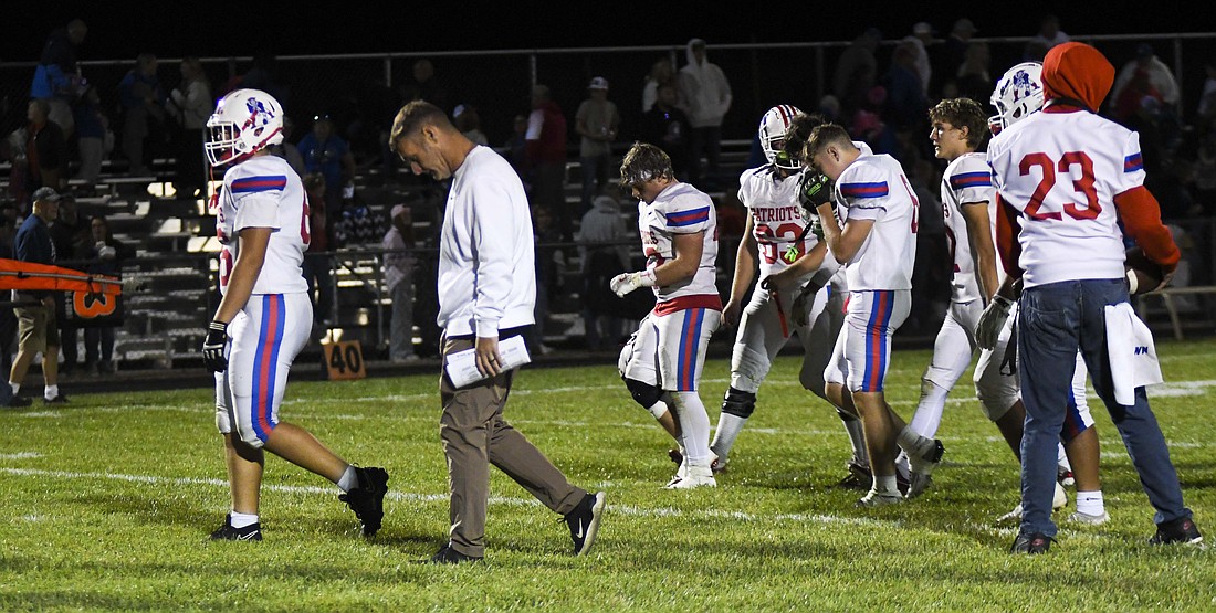 Jay County coach Eddie Fields and his players walk away after making their way through the handshake line following Friday’s 21-14 defeat to Southern Wells. The result snapped Southern Wells’ 25-game Allen County Athletic Conference losing streak, dating back to 2019. (The Commercial Review/Ethan Oskroba)