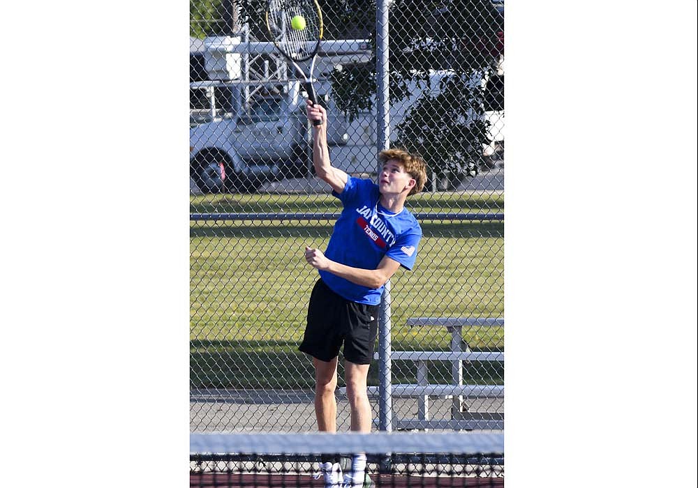 Jay County’s Gabe Overton blasts a serve during his match at No. 2 doubles on Monday. Overton and Brock Wasson won the last 11 games of a 6-1, 6-0 win against Tyko Holowell and David Miller that helped contribute to a Patriot sweep over Muncie Central. (The Commercial Review/Ethan Oskroba)
