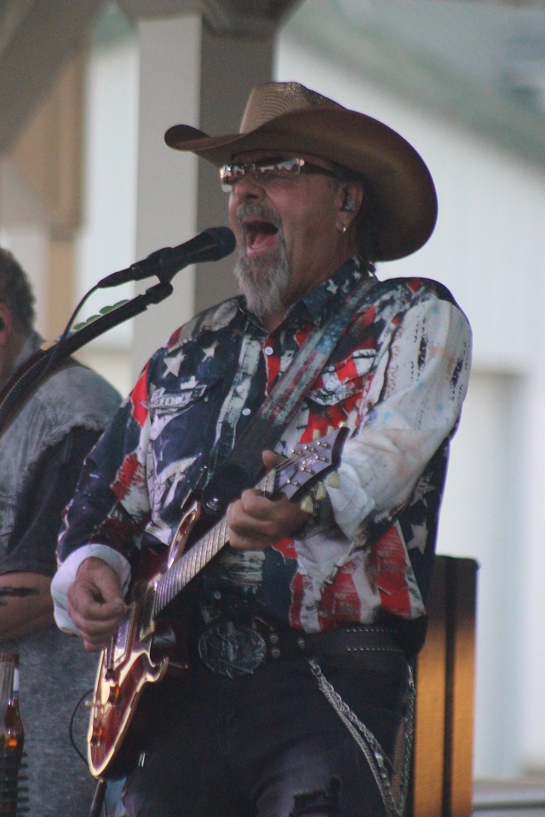 Brian Stoney Gallagher, lead singer with Outlaw Nation, belts out a song Friday at Jay County Fairgrounds. The Indianapolis band, coordinated by local marketing group 260 Events, performed following Jay County Chainsaw Carving Invitational and Vendor Fair festivities Friday. The invitational continues from 9 a.m. to 6:30 p.m. today and 9 a.m. to 3 p.m. Sunday, with a carving auction slated for Sunday. (The Commercial Review/Bailey Cline)