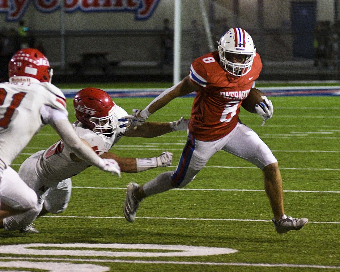 Carter Fugiett of Jay County High School turns the corner on a pair of Adams Central defenders, including Joey Everett (left), during the second half Friday. Fugiett was one of four Patriots to rush for 20-plus yards, joining Garrett Bennett (29), Leighton Brown (21) and Brady Jetmore (20). (The Commercial Review/Ray Cooney)
