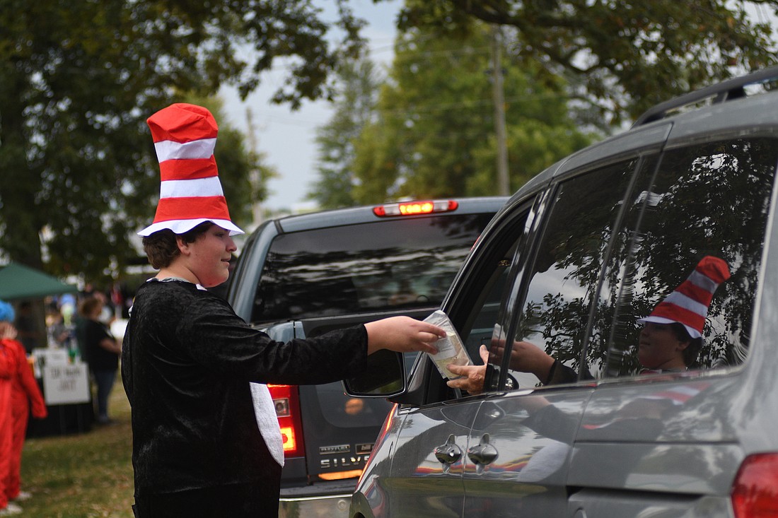 Fred Howell, 13, hands out an item at the Fellowship Baptist Church table during the Jay County Cancer Cruise on Saturday at Jay County Fairgrounds. Cancer survivors received a variety of items from local organizations and businesses. The event also included a car show and kids carnival. (The Commercial Review/Ray Cooney)