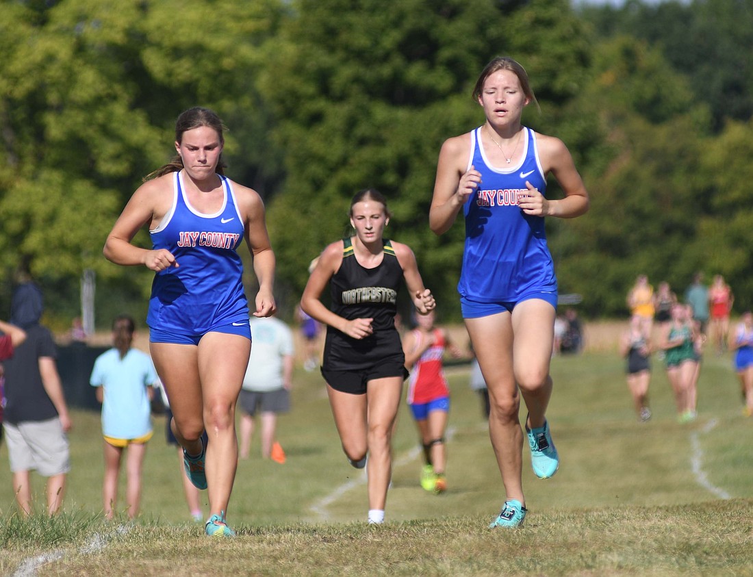 Jay County High School’s Brooklynn Byrum (left) and Abby Fifer run side-by-side during the Randolph Southern Invite on Saturday. Byrum and Fifer finished 11th and 12th to help th Patriot girls win their first invitational of the season. (The Commercial Review/Ray Cooney)
