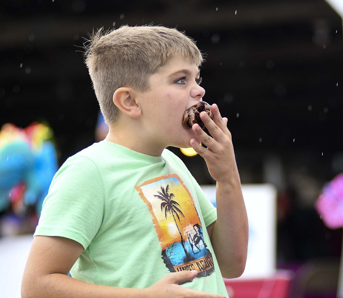 Gage Reynolds, 9, shoves a confection in his mouth while competing in a cupcake eating contest Saturday evening during the Jay County Cancer Society’s Cruise, Car Show and Carnival at Jay County Fairgrounds. (The Commercial Review/Ray Cooney)