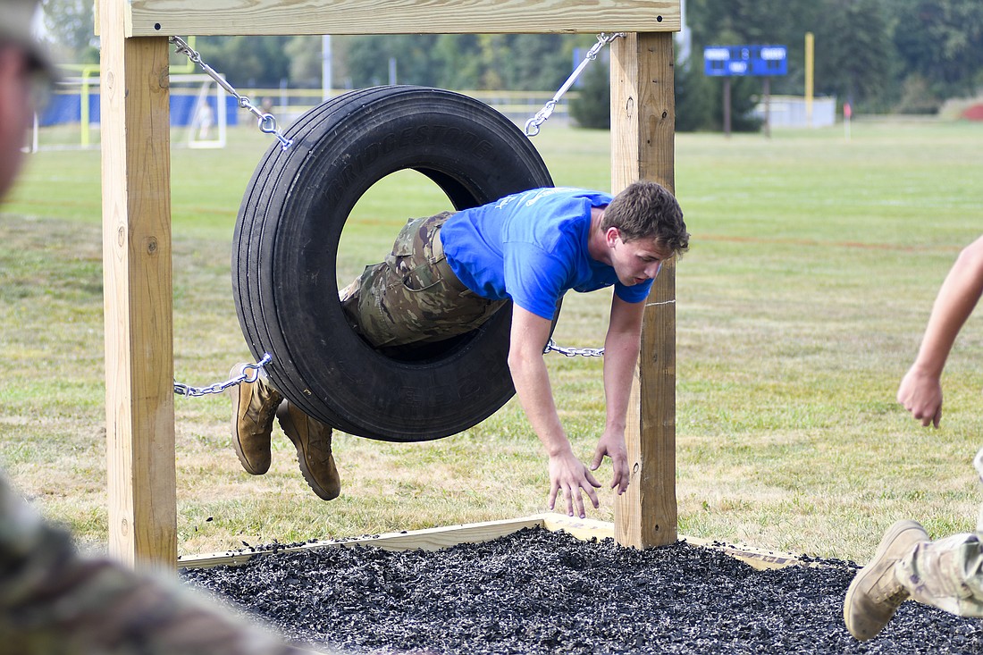 Wyatt Bihn of the Jay County JROTC squad launches himself through a tire as part of the cross country rescue drill on Saturday’s JROTC Patriot Raider Challenge Competition. Bihn went directly from carrying a fake stretcher with weights to flying through the tire. (The Commercial Review/Andrew Balko)