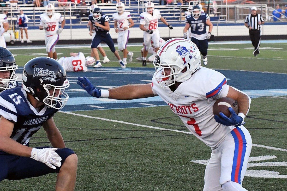 Jay County High School senior Brady Jetmore prepares to stiff arm Woodlan’s Liam Hertig during the Patriots 21-7 victory on Friday. Jetmore scored the go-ahead touchdown for JCHS and added two interceptions to help seal the deal. (The Commercial Review/Andrew Balko)