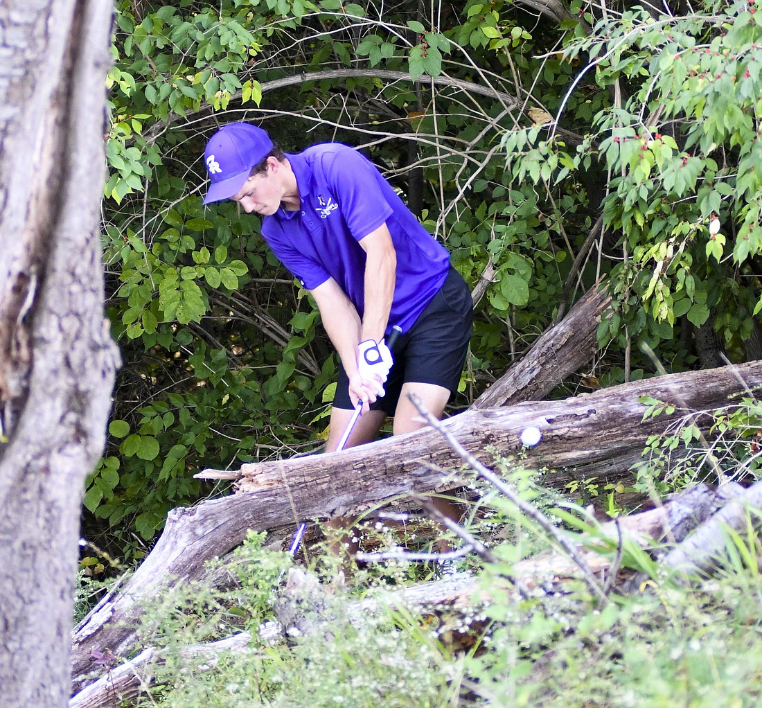 Fort Recovery High School senior Reece LeFevre threads his golf ball through a pair of logs to give him one final shot at tying for the final state berth during the OHSAA Division III Southwest District tournament at PipeStone Golf Club on Monday. (The Commercial Review/Andrew Balko)