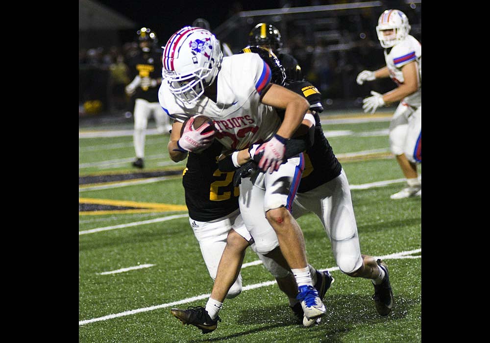Jay County High School junior Benson Barnett tries to pull away from a pair of South Adams tackles during the Patriots’ 42-16 loss Friday night in Berne. The host Starfires scored quickly, needing just 11 seconds for Tytus Lehman’s opening 65-yard touchdown run, and JCHS trailed 28-0 at the end of the first quarter as it slipped to 2-5 overall and 1-4 in the Allen County Athletic Conference. (The Commercial Review/Ray Cooney)