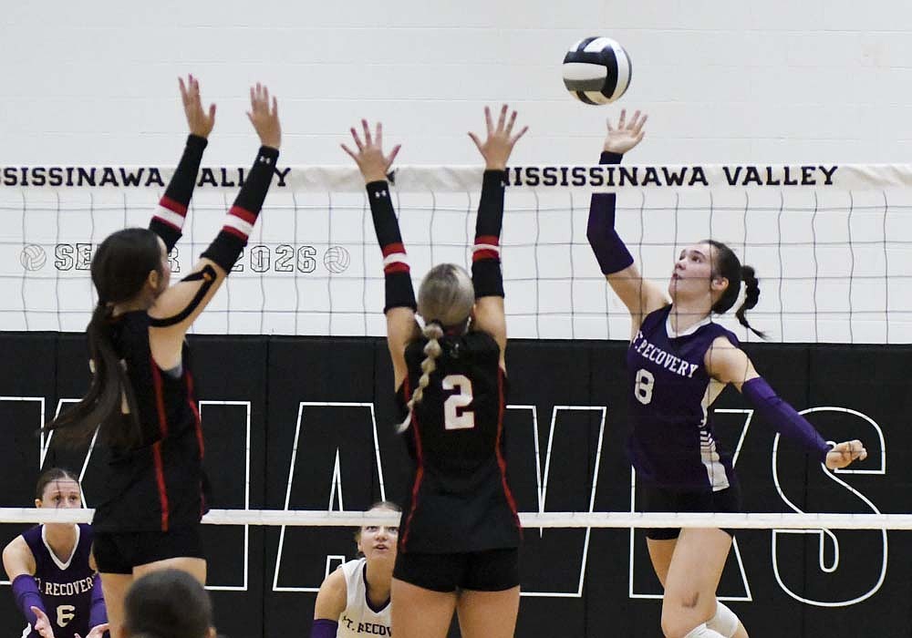 Cameron Muhlenkamp of the Fort Recovery High School volleyball team spikes the ball at the block of Cora Hoggatt (left) and Danika Neargarder of the Mississinawa Valley Blackhawks. Muhlenkamp’s 10 kills led the Indians in their 25-19, 25-17, 25-22 win on Monday.