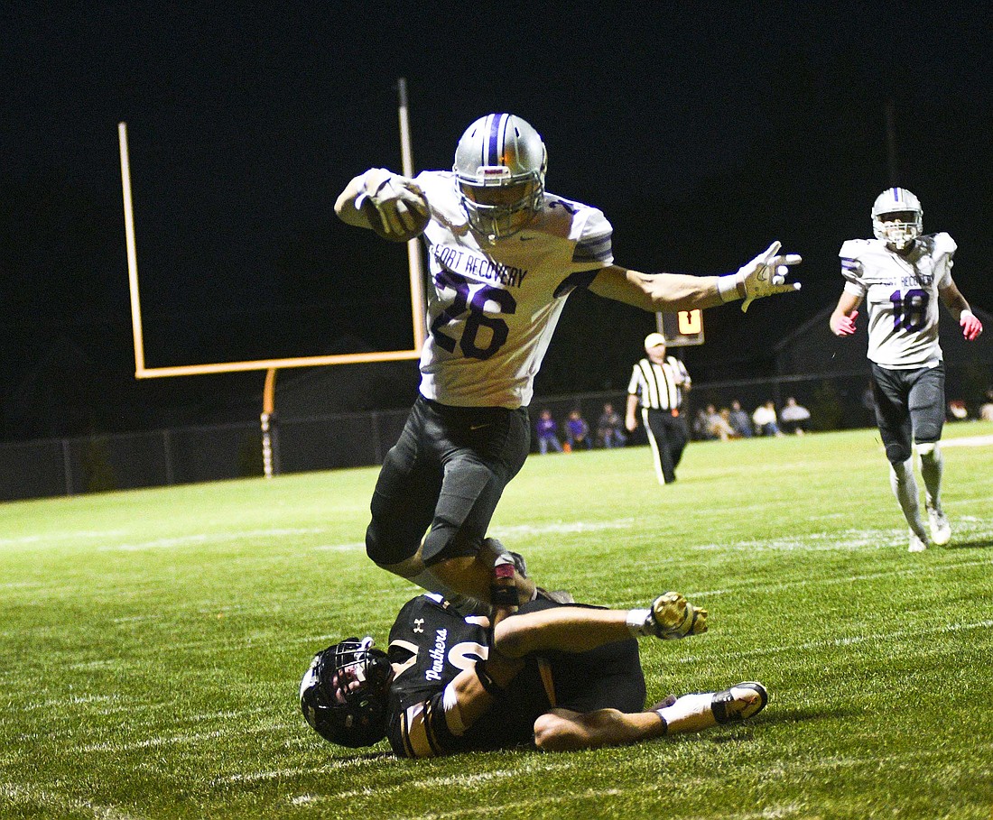 Fort Recovery High School running back Reece Wendel tries to jump over Rhen Carpenter of the Parkway Panthers on Friday during the first half of the Indians’ 41-27 victory. Wendel totaled 275 yards and three touchdowns for FRHS while also snagging the game-sealing interception. (The Commercial Review/Ray Cooney)