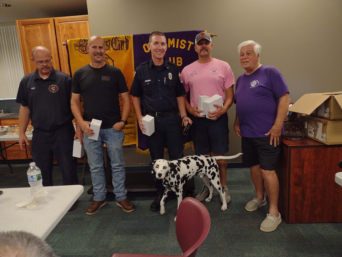 Portland Evening Optimist Club recently honored Portland Fire Department. Pictured are Portland firefighters Chuck Denney, Brandon Clifton, Zach Hudson and Fire Chief Mike Weitzel accepting cups from Optimist club member Mike Aker, with fire department dog Huey, in appreciation for the crew’s service to the community. (Photo provided)