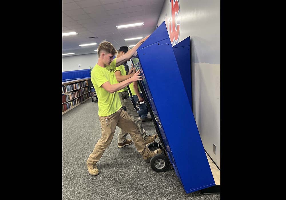 Muhlenkamp Building Corporation was putting on the final touches to the Jay County Junior-Senior High School rehabilitation project following the September 2024 tornado. Pictured, Blake Collins moves a set of lockers back into place in the Instructional Media Center (library) at the school. Collins was working with Jeff Knapschaefer, Gabe Muhlenkamp, Cody McFarland and Owen Muhlenkamp. Junior high students are expected to be back in their regular classrooms for the first time in more than a year when they return from fall break on Monday. (The Commercial Review/Ray Cooney)