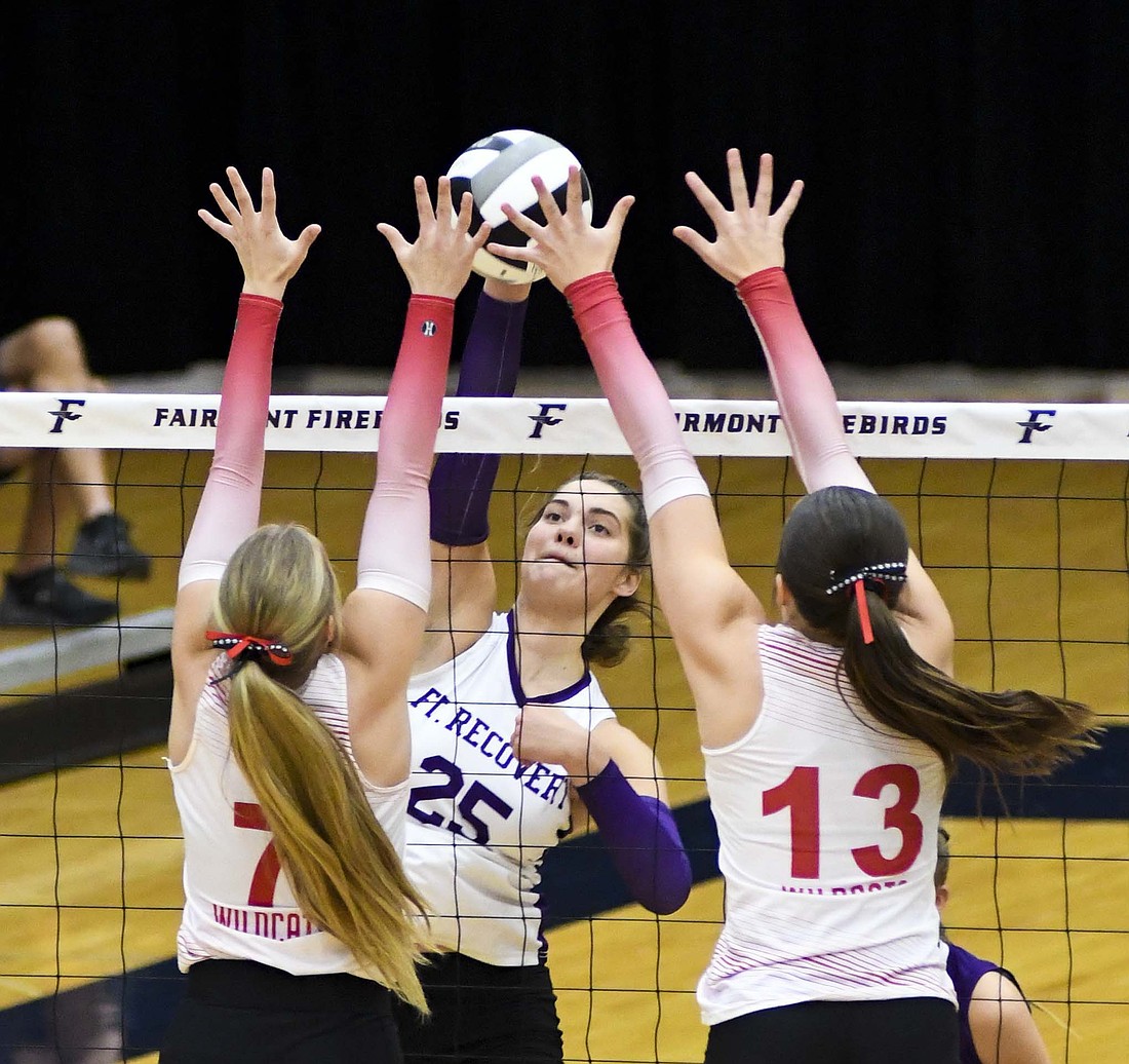 Fort Recovery High School’s Bridget Homan swings at a ball while Houston’s Brylee Breeze (7) and Elizabeth Pollock (13) try to put a block on it. Homan led the Indians with 11 kills as they beat Houston 25-11, 25-12, 25-14 for the district title. (The Commercial Review/Andrew Balko)
