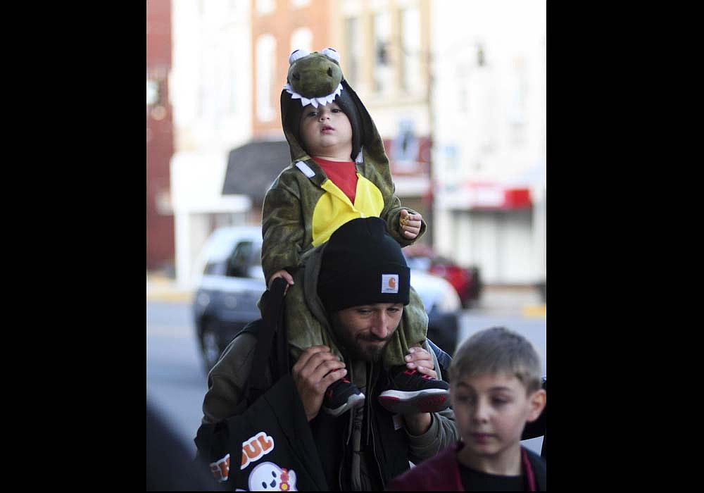 Two-year-old Alden Zaugg of Portland rides on dad Lane Zaugg’s shoulders Friday night while trick-or-treating at the corner of Meridian and Main streets in downtown Portland. Local businesses and organizations lined the streets and Brick Alley to take part in the Jay County Chamber of Commerce Merchant Trick or Treat. (The Commercial Review/Ray Cooney)