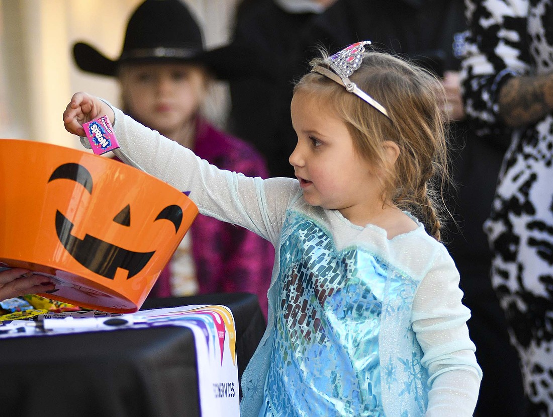 Scarlett Eastman, 4, Portland, picks out some candy from the Jay County Drug Prevention Coalition stop during Friday’s Jay County Chamber of Commerce Merchant Trick-or-Treat in Portland. Eastman was dressed as Elsa from the Disney movie “Frozen.” (The Commercial Review/Ray Cooney)