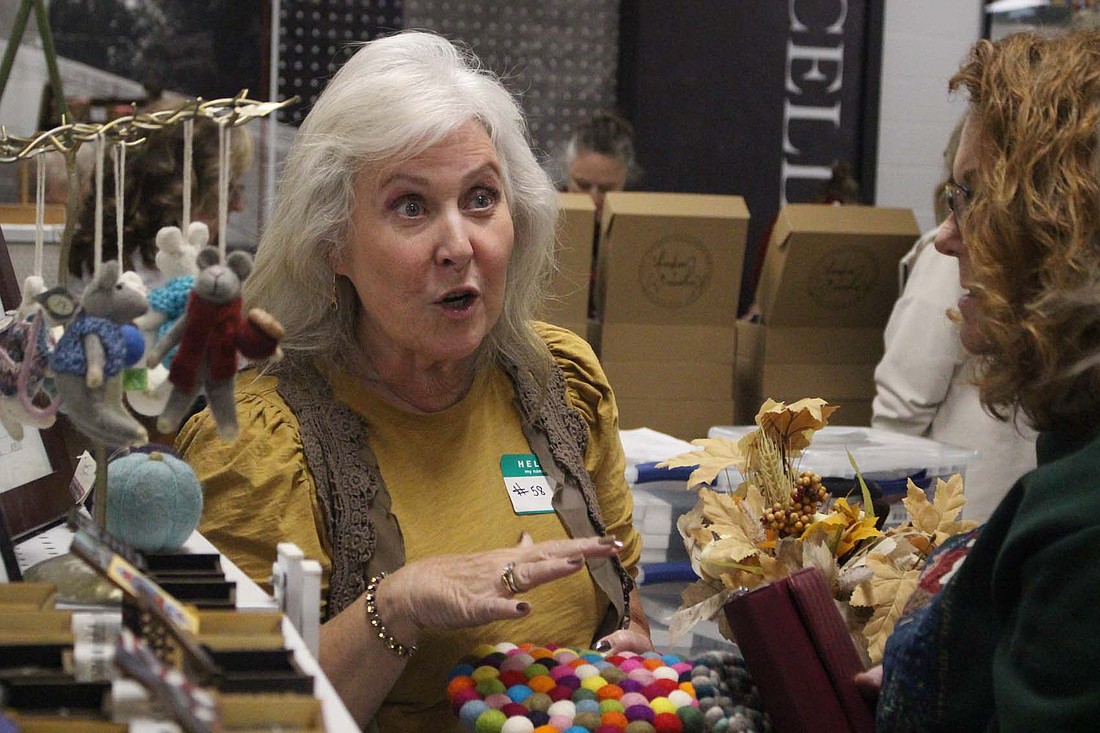 Lori Lloyd of Farmland chats with customer Julia Howard on Saturday during The Delts’ Holiday Crafts and Gifts Show. Xi chapter of Delta Theta Tau celebrated its 40th anniversary hosting the show at Jay County Junior-Senior High School. (The Commercial Review/Bailey Cline)