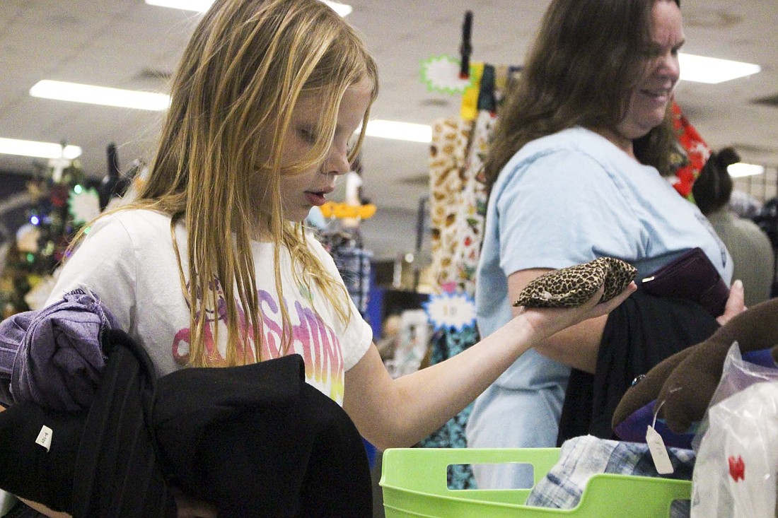 Amarah Coffey, 10, Muncie looks through sewn items at a stall Saturday during the The Delts’ Holiday Crafts and Gifts Show at Jay County Junior-Senior High School. This year marked the 30th show, which generates most of the $30,000 to $35,000 the sorority raises each year. (The Commercial Review/Bailey Cline)