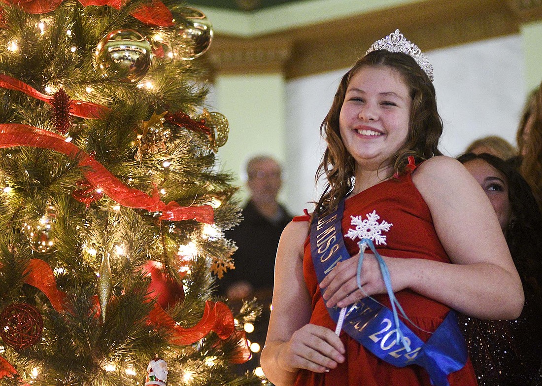 Jay County Chamber of Commerce and Arts Place got the holiday season kicked off Friday night with Christmas at the Courthouse and the Holiday Benefit Auction. Pictured above, Little Miss Winterfest Taylor Lee reacts after lighting the community Christmas tree during Friday’s Christmas at the Courthouse event, the first among this year’s Winterfest activities. The evening also included a performance by the Jay County High School choirs. (The Commercial Review/Ray Cooney)